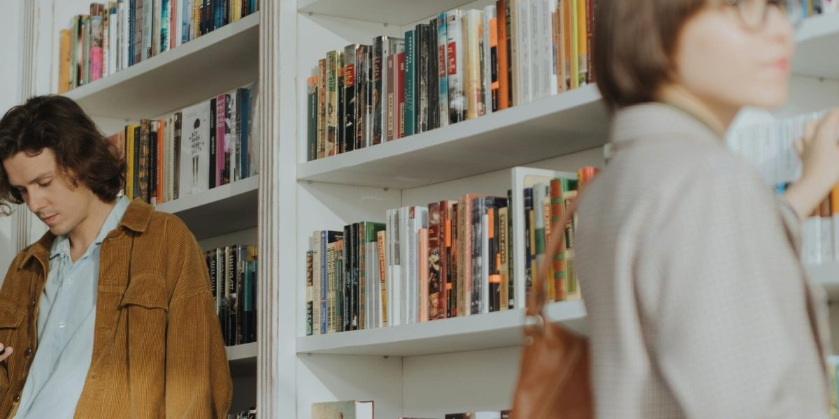 Person browsing books on a shelf in a bookstore