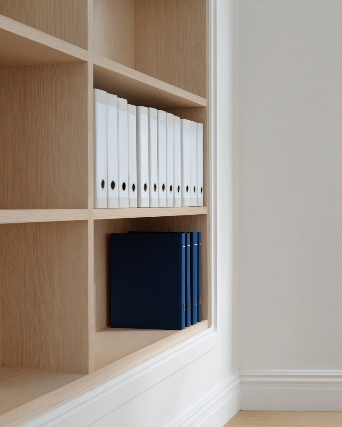 A person carefully arranging books in a specific order, symbolizing the importance of a structured reading plan.