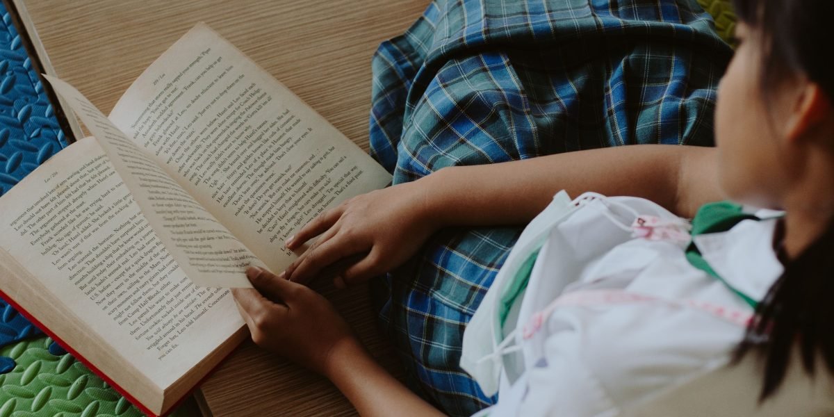 A young person immersed in an engaging book, reflecting the timeless appeal of A Wrinkle in Time.