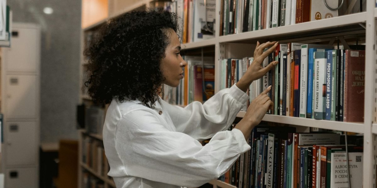 A person leisurely browsing the shelves of a library or independent bookstore, searching for their next read.