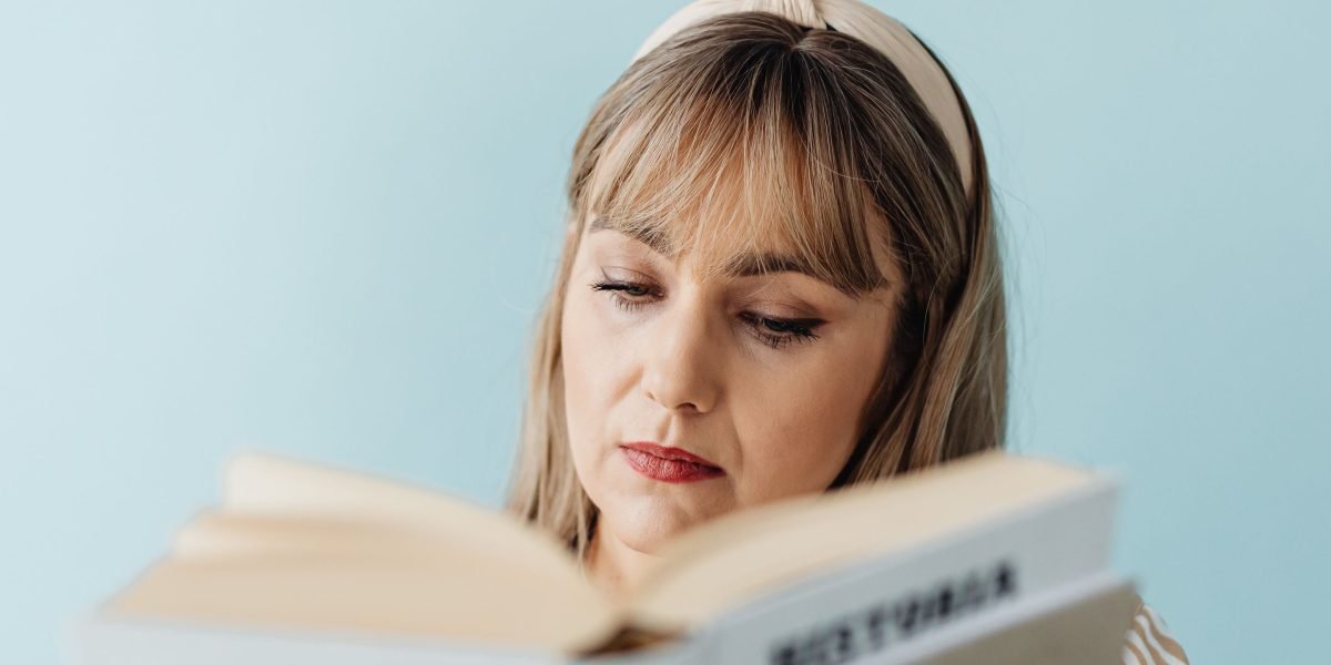 A person deeply absorbed in reading a fantasy novel, clearly enjoying the story.