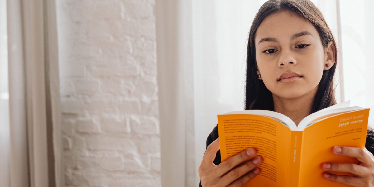 A person completely immersed in reading a captivating thriller novel.