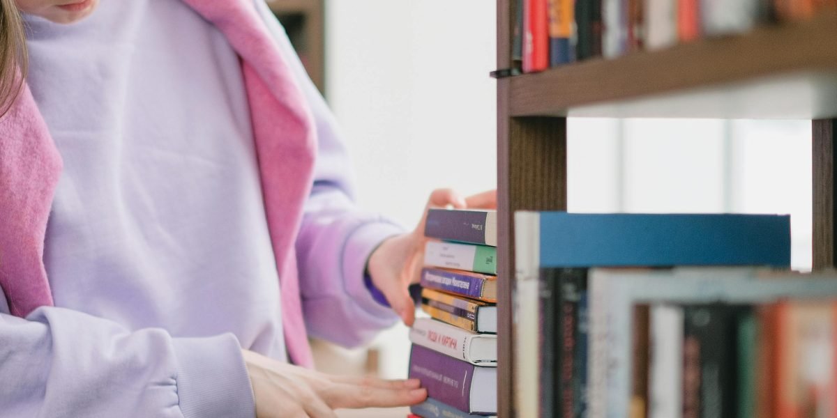 A person contemplating choices in a bookstore or library, reflecting the decision-making process.