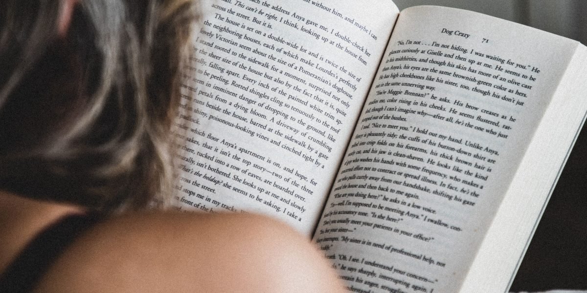 A person engrossed in reading an adventure novel, symbolizing the immersive experience of literature.