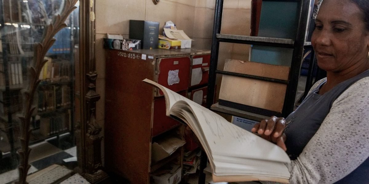 A person carefully examining vintage books on a shelf, evoking the experience of a book collector or student.